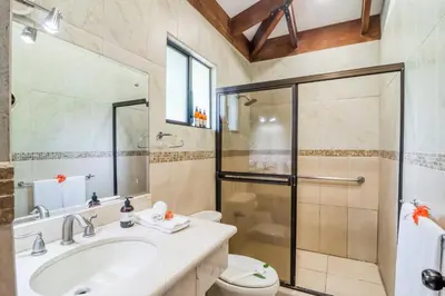 a bathroom with a shower and a sink and a toilet at Villa Sol 35 & 36 in Playa Hermosa
