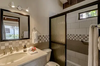 a bathroom with a sink and a toilet and a mirror at Villa Sol 35 & 36 in Playa Hermosa