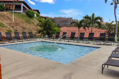 a swimming pool with a fountain in the middle at Villa Sol 35 & 36 in Playa Hermosa