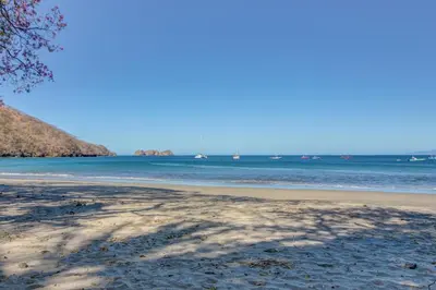 a shadow of a tree on the beach at Villa Sol 35 & 36 in Playa Hermosa