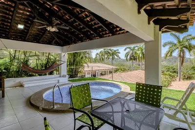 a patio with a table and chairs and a swimming pool at Villa Sol 35 & 36 in Playa Hermosa