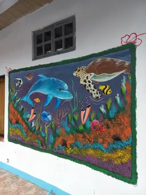 a painting of a dolphin and a turtle on a wall at Hotel La Uvita in Puerto Limón