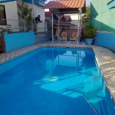 a large swimming pool with blue water at Hotel La Uvita in Puerto Limón