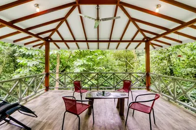 a patio with a table and chairs on a deck at Lost Pools Bungalows in Ojochal