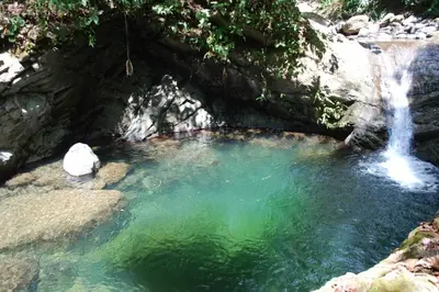 a small pool of water with a waterfall at Lost Pools Bungalows in Ojochal