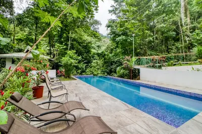 a patio with chairs and a swimming pool at Lost Pools Bungalows in Ojochal