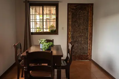 a dining room with a table and chairs and a door at Mai Ke Kai Surf House in Tamarindo