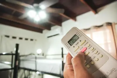 a person holding a remote control in a room at Mai Ke Kai Surf House in Tamarindo