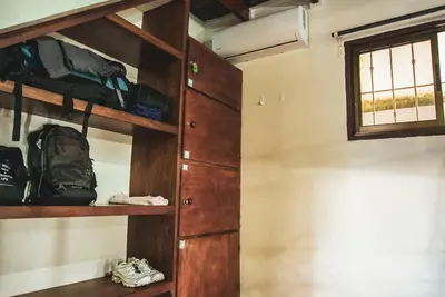 a room with wooden shelves and a window at Mai Ke Kai Surf House in Tamarindo