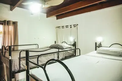 two bunk beds in a room with a ceiling at Mai Ke Kai Surf House in Tamarindo
