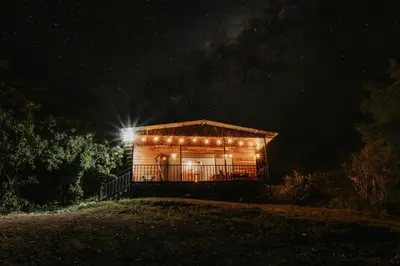 a wooden cabin lit up at night with lights at Finca Murillo in Monteverde Costa Rica