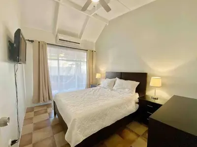 a bedroom with a white bed and a window at Beach Bliss - 1BR Villa with Pool 2 blocks from ocean in Jacó