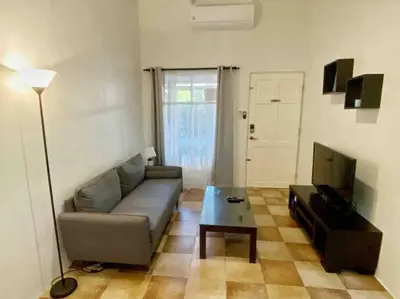 a living room with a couch and a television at Beach Bliss - 1BR Villa with Pool 2 blocks from ocean in Jacó
