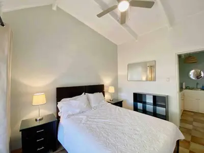 a bedroom with a white bed and a ceiling fan at Beach Bliss - 1BR Villa with Pool 2 blocks from ocean in Jacó