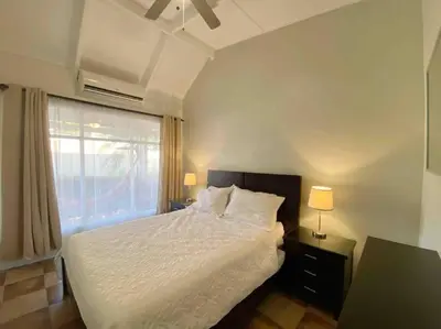 a bedroom with a white bed and a window at Beach Bliss - 1BR Villa with Pool 2 blocks from ocean in Jacó