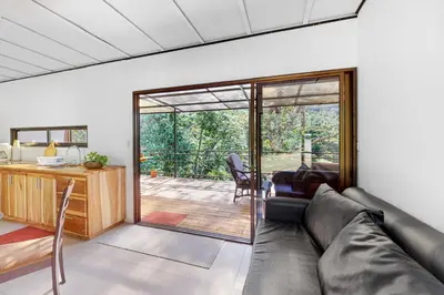 a living room with a couch and a sliding glass door at Aqua Tarrazu in Santa Cruz