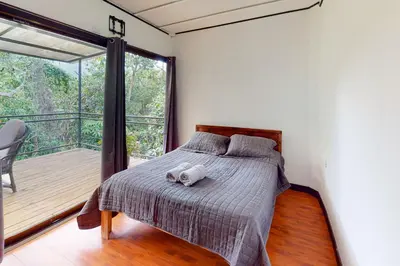 a bedroom with a bed with a stuffed animal on it at Aqua Tarrazu in Santa Cruz