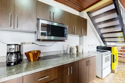a kitchen with a microwave and a counter top at El Portal Tarrazu in Santa Cruz