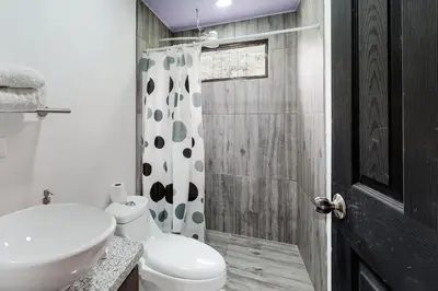 a bathroom with a toilet and a sink and a shower at El Portal Tarrazu in Santa Cruz