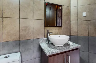 a bathroom with a white sink and a mirror at El Portal Tarrazu in Santa Cruz