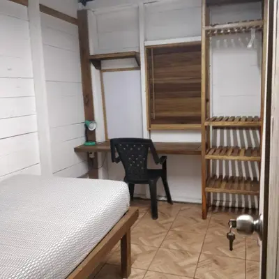 a bedroom with a bed and a chair in a room at Granja Integral Luz Del Corazon in Rincón de la Cruz