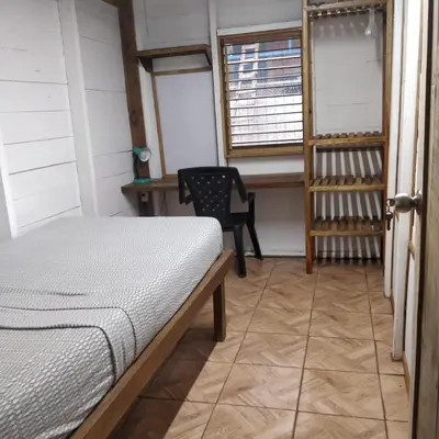 a bedroom with a bed and a chair and a window at Granja Integral Luz Del Corazon in Rincón de la Cruz