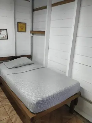 a bed in a room with white walls at Granja Integral Luz Del Corazon in Rincón de la Cruz