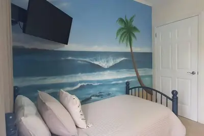 a bedroom with a palm tree mural and a bed at Casita Del Mar in Herradura