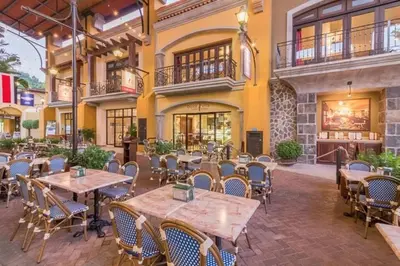 a restaurant with wooden tables and chairs in front of a building at Casita Del Mar in Herradura