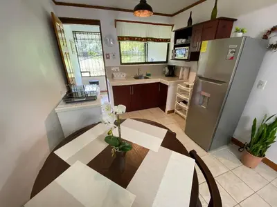a kitchen with a table and a stainless steel refrigerator at Apto Cielo Azul in Manuel Antonio