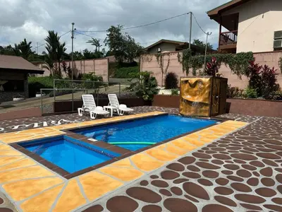 a swimming pool with two chairs and a fountain at Villa Ali Río Cuarto in Río Cuarto