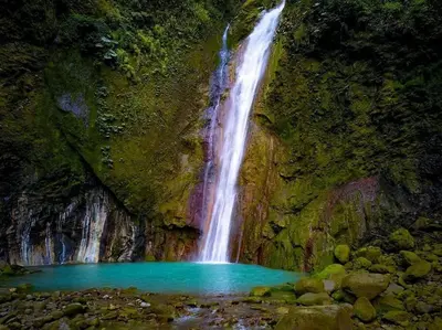 a waterfall in a cave with a pool of blue water at Villa Ali Río Cuarto in Río Cuarto