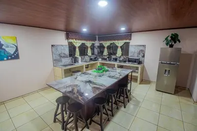 a kitchen with a table and stools in a room at Villa Ali Río Cuarto in Río Cuarto