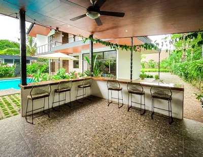 a bar with stools in front of a house at Hector House in Uvita