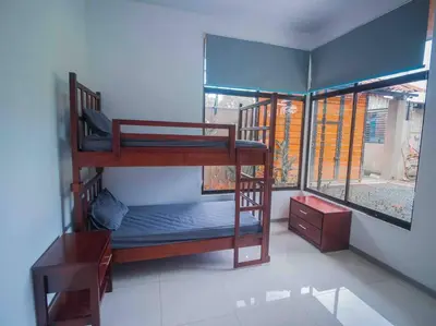 a room with two bunk beds and a window at Hector House in Uvita