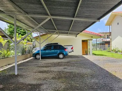 a blue car parked in a garage with a roof at Volcano View Apartments in Fortuna