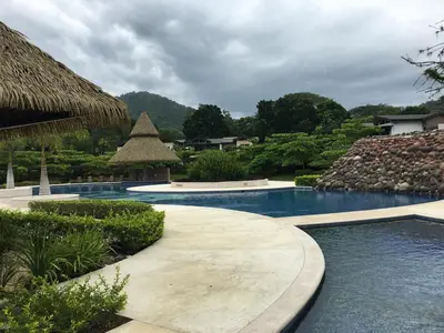 a swimming pool in a resort with a resort at Villa Paraiso do Mar in Jacó