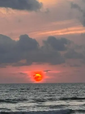 a sunset over the ocean with the sun setting at Villa Paraiso do Mar in Jacó
