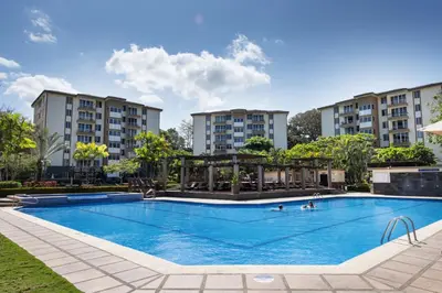 a pool at a hotel with buildings in the background at Paradise Jaco Beach Apartment in Jacó