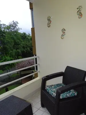 a chair sitting on a balcony with a view at Paradise Jaco Beach Apartment in Jacó