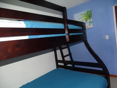 a bunk bed in a room with a blue wall at Paradise Jaco Beach Apartment in Jacó