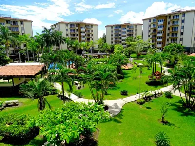an aerial view of a park with palm trees and buildings at Paradise Jaco Beach Apartment in Jacó