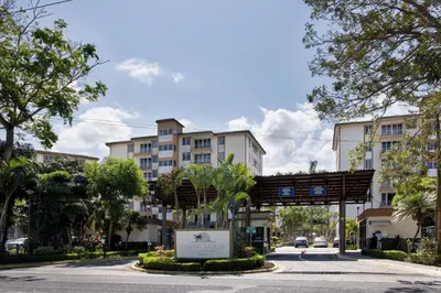 a street with buildings and a sign in the middle at Paradise Jaco Beach Apartment in Jacó