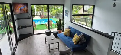 a living room with a blue couch and some windows at Villas Töcu - Casa Colibrí in Fortuna