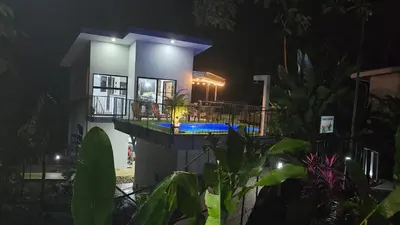 a house lit up at night with a pool at Villas Töcu - Casa Colibrí in Fortuna