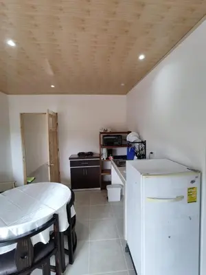 a kitchen with a table and a white refrigerator at Apartamentos La Paz in Liberia