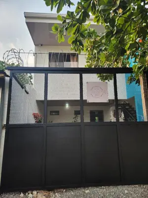 a black gate in front of a house at Apartamentos La Paz in Liberia