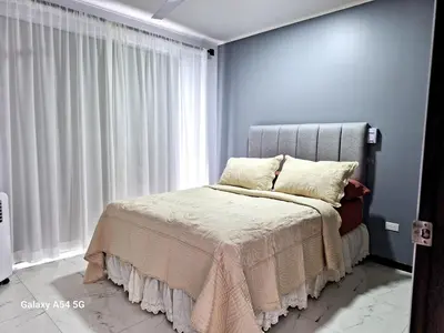 a bedroom with a bed and a large window at Casa Victoria CR in San Isidro
