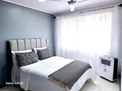 a bedroom with a large bed and a window at Casa Victoria CR in San Isidro