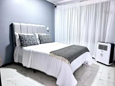 a bedroom with a white bed and a window at Casa Victoria CR in San Isidro